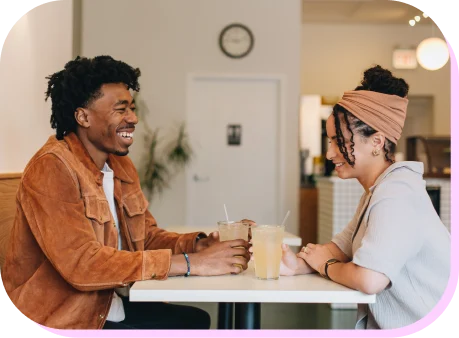 A smiling man and woman sitting in a restaurant.