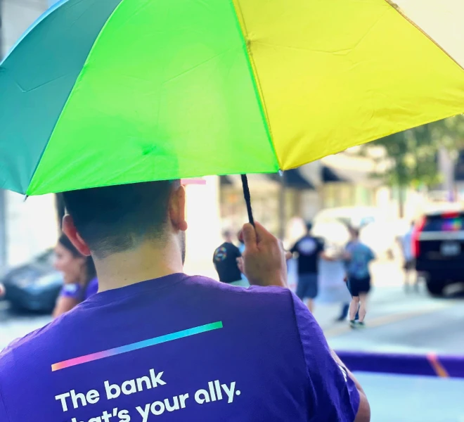 A Pride participant carries a rainbow umbrella in the parade.