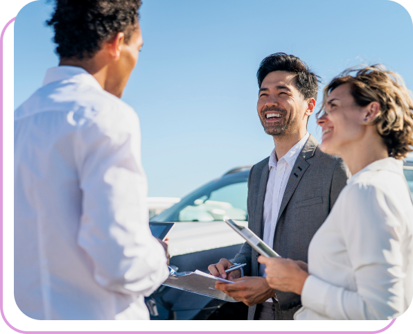 Three dealers talking in a car lot.