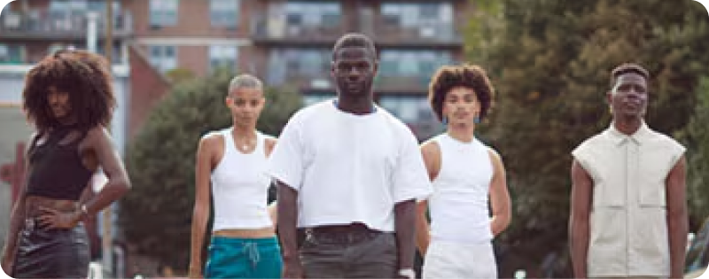 Five business owners with dark skin pose outside and address the camera.