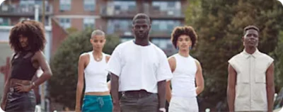 Five business owners with dark skin pose outside and address the camera.