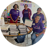 a smiling group of Ally employees displaying financial workbooks.