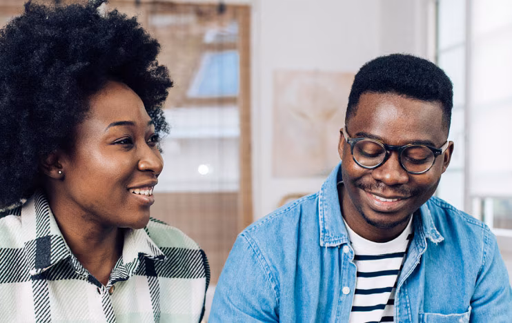 A smiling couple sits at a cafe