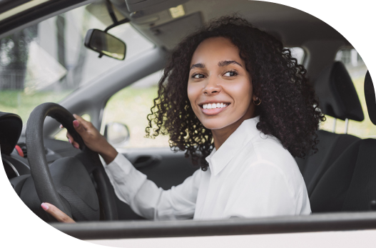 Customer seated in the driver’s seat of a vehicle, smiling.