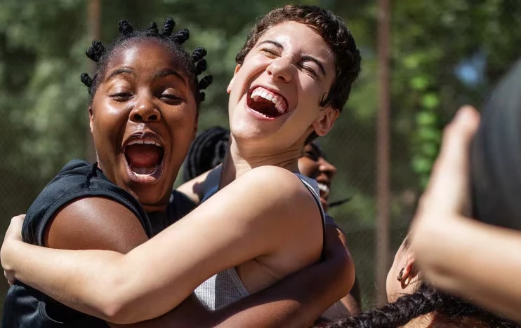 Teammates celebrate a victory on an outdoor basketball court