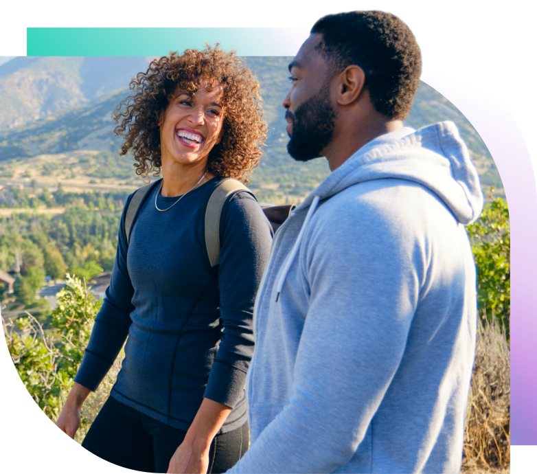A smiling couple hikes in the mountains. 
