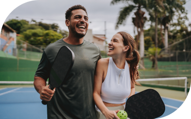 Young couple on a pickleball court celebrates winning their doubles match