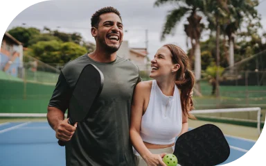 Young couple on a pickleball court celebrates winning their doubles match