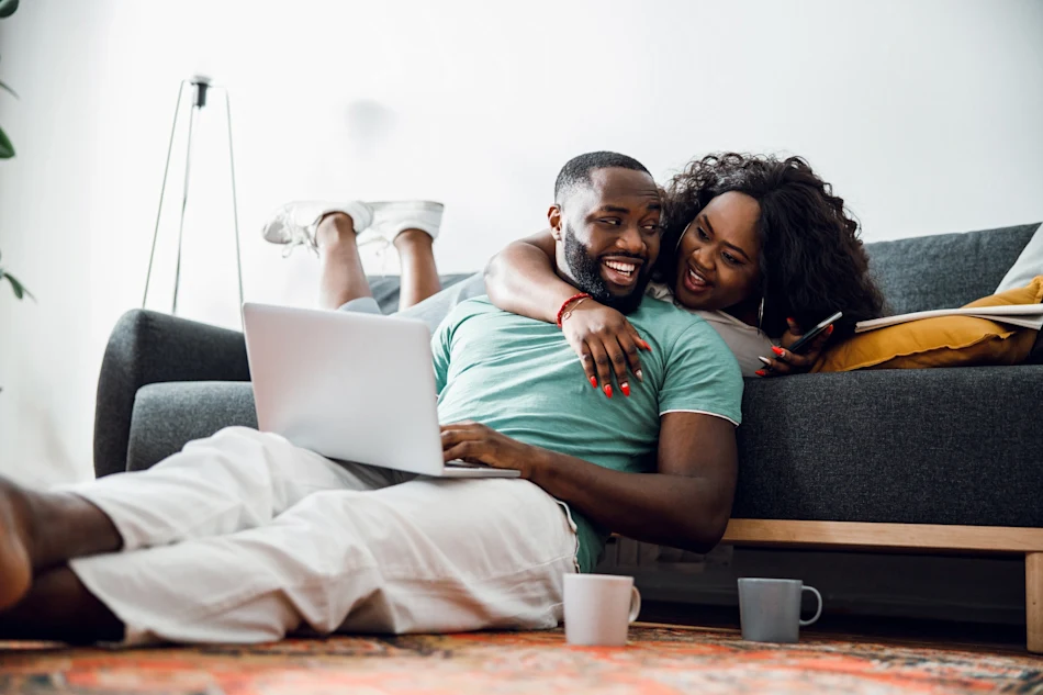 A couple looks over their investment accounts at home on a laptop.
