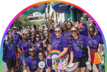 A group of smiling people wearing Ally shirts celebrate together at Pride.