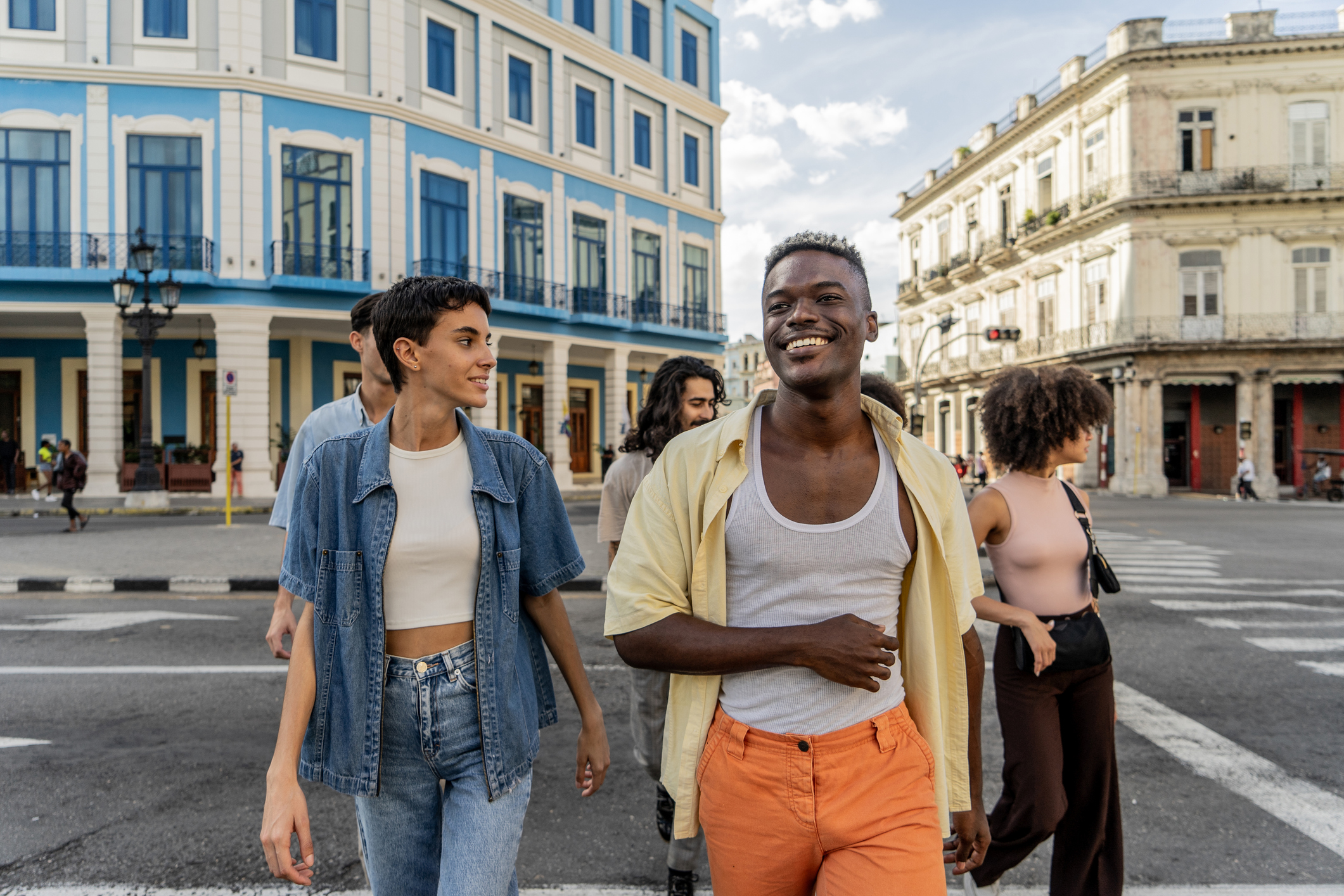 A group of young people on vacation happily walk through a city
